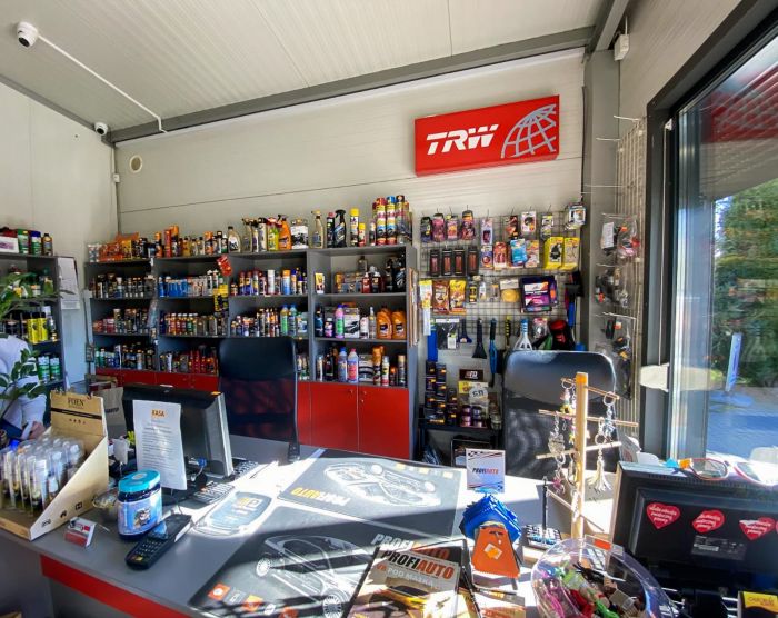 Wnętrze sklepu motoryzacyjnego Auto-Parts z widocznym asortymentem części samochodowych